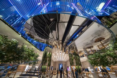 New York City, New York - 14 Haziran 2025: Apple Store 5. Cadde iç mekanı gece aydınlandı teknoloji gösterimleri ve temiz mimari.