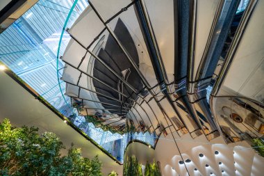 Modern binadaki parlak aynalı merdivenlerdeki ışık ve yansımaların soyut bileşimi.