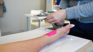 Fizyoterapist rehabilitasyon sırasında genç bir kadına el desteği hazırlar..