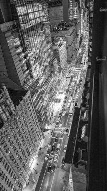 Manhattan caddesine bakan hava gecesi perspektifi arabalar ve ışıklarla dolup taşıyor.