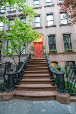 Gündüz vakti New York 'ta harici merdivenleri olan klasik tuğla evler..