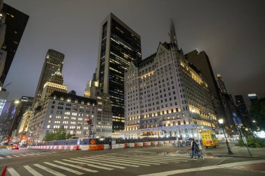 New York City, New York - 14 Haziran 2025: Manhattan gökdelenleri New York 'ta 59. Cadde boyunca gece parlak şehir ışıklarıyla aydınlatıldı.