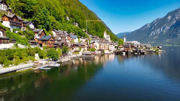 Hallstatt 'un göz kamaştırıcı hava manzarası, Avusturya Alpleri' ne kurulmuş görkemli köy ve sakin göl görüntüsü.