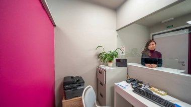 Şık masa, bilgisayar ve hoş geldin atmosferiyle modern tıp bürosu resepsiyonu.