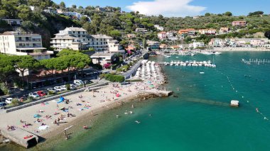 Pürüzsüz çakıl taşları, kristal suyu ve manzaralı yaz arkaplanı olan Portovenere kıyıları.