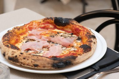 Geleneksel İtalyan pizzacısıyla fırından yeni çıkmış bir pizza..