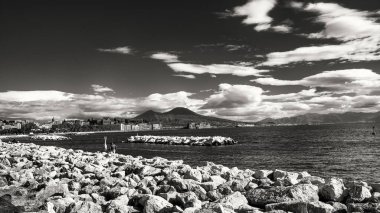 Güzel Mergellina rıhtımı, alacakaranlıkta kayıklar ve fonda çarpıcı bir siluet..