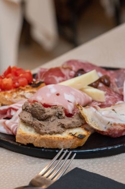 Geleneksel İtalyan şarküteri ve peynir tahtası taze ekmek ve süslemelerle servis ediliyor..