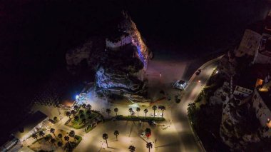 Gece Tropea 'nın ışıldayan binalar ve yaz mevsiminde karanlık denizlerle drone çekimi..