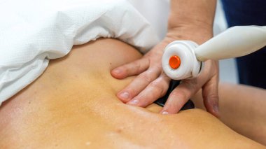 Tedavi için TECAR terapisini kadın hastaların omuzlarında kullanıyor.. 