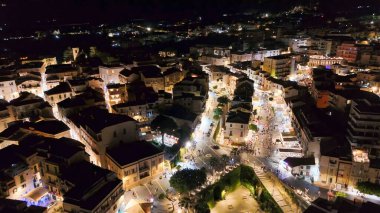 Gece Tropea 'nın ışıldayan binalar ve yaz mevsiminde karanlık denizlerle drone çekimi..