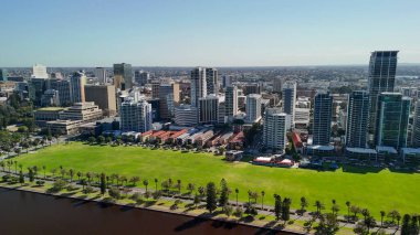 Kuğu Nehri 'nden Perth şehrinin gündüz manzarası parlak güneş ışığı altında gökdelenleri gösteriyor.