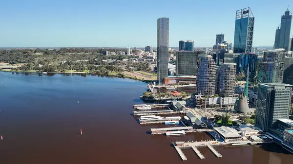 Kuğu Nehri 'nden Perth şehrinin gündüz manzarası parlak güneş ışığı altında gökdelenleri gösteriyor.