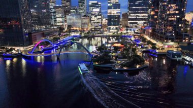Elizabeth Quay 'in gece panoraması ve Perth' teki kavisli yaya köprüsü hava aracından görüldü..