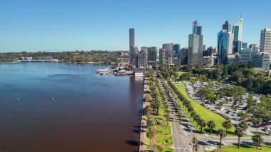 Kuğu Nehri 'nden Perth şehrinin gündüz manzarası parlak güneş ışığı altında gökdelenleri gösteriyor.