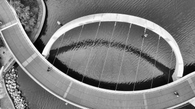 Elizabeth Quay köprüsünün Perth 'teki nehir suyunu yansıtan siyah beyaz manzarası.