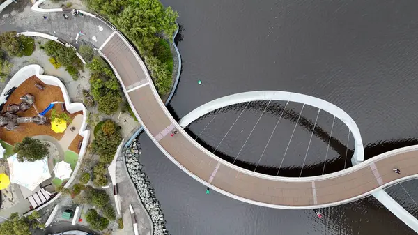Elizabeth Quay köprüsünün Perth 'teki nehir suyunu yansıtan manzaralı gün batımı manzarası.