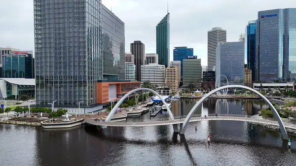 Elizabeth Quay köprüsünün Perth 'teki nehir suyunu yansıtan manzaralı gün batımı manzarası.