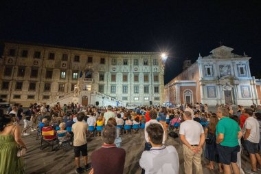 Pisa, İtalya - 12 Temmuz 2025: Pisas tarihi Piazza dei Cavalieri 'de pırıl pırıl sokak lambaları altında canlı bir gecenin tadını çıkaran turistler. 