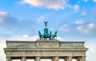 Berlin 'deki Brandenburg Kapısı dramatik bulutlarla dolu renkli günbatımı gökyüzü ile aydınlandı.