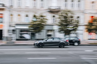 Ukrayna, Kyiv - 2 Ağustos 2021: Gri Ford Fusion (Kuzey Amerika) arabası sokakta hareket ediyor. Yazı