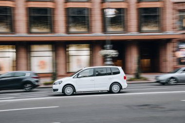 Ukrayna, Kyiv - 2 Ağustos 2021: Beyaz Volkswagen Touran arabası sokakta hareket ediyor. Yazı
