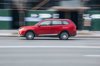Ukrayna, Kyiv - 7 Ocak 2023: Red Mitsubishi Outlander arabası yolda ilerliyor. Yazı