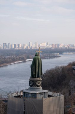 KYIV, UKRAINE - 07 Ocak 2023: Kyiv tepelerindeki Aziz Vladimir Anıtı. Yaya köprüsü ve Büyük Vladimir Anıtı ile Dnipro Nehri 'nin manzarası.