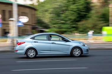 Ukrayna, Kyiv - 16 Temmuz 2021: Açık Mavi Hyundai Solaris arabası sokakta hareket ediyor. Yazı