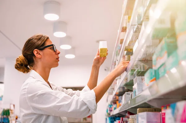 薬局で働く女性は薬を探す — ストック写真