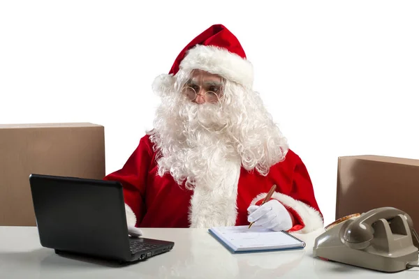 圣诞老人用笔记本电脑在办公室里工作 — 图库照片