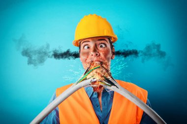 Worker girl with helmet breaks an electric cable