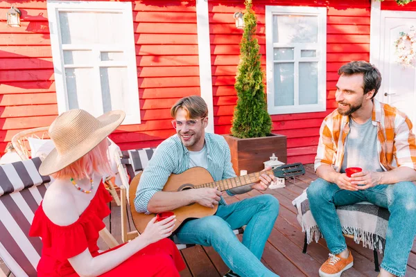 stock image Group of friends have a picnic and play with guitar