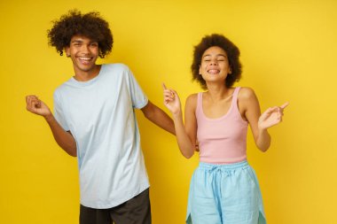 Mutlu ve kaygısız afro erkek arkadaş ve kız arkadaş birlikte dans eder.