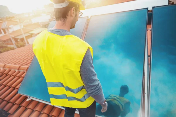 Człowiek Kasku Montuje Panel Słoneczny Gorącą Wodę Dachu — Zdjęcie stockowe