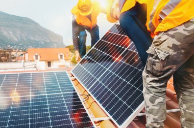 İşçiler elektrik ve sıcak su için güneş paneli ile sistemi birleştiriyorlar