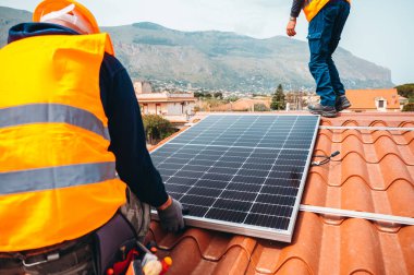 İşçiler elektrik ve sıcak su için güneş paneli ile sistemi birleştiriyorlar