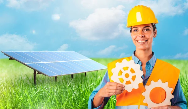Trabalhador Detém Duas Peças Engrenagens Contra Frente Painel Solar — Fotografia de Stock