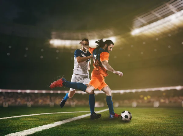 サッカー選手2人がスタジアムでボールを追いかける — ストック写真