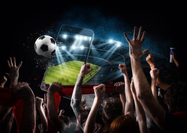 Futbol taraftarları stadyumda cep telefonu ve top kullanıyorlar.