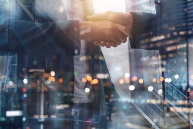 İş adamlarının takım çalışması ve ortaklık konsepti olarak ofiste el sıkışması