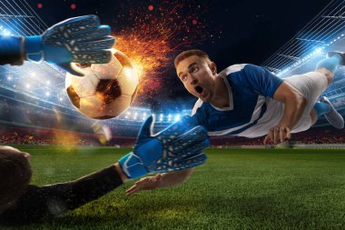 Futbol stadyumunda ateşli bir topla güçlü bir futbolcu vuruşu.