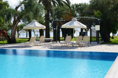 Yüzme havuzu manzarası ve plaj, Korfu adası, Yunanistan yakınlarındaki zeytin ağaçları