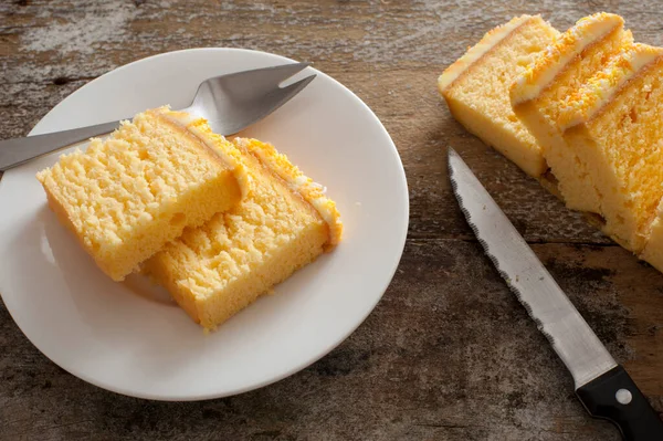 바닐라 스펀지 케이크에 케이크 포크와 곁들여 접시에 요리용 케이크 스톡 사진
