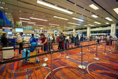 SINGAPORE - CIRCA JANUARY, 2020: İnsanlar Singapur Changi Havaalanı 'nda kontrol için sırada bekliyor.
