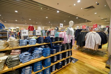 SINGAPORE - CIRCA JANUARY, 2020: Singapur Changi Havaalanı 'ndaki Uniqlo mağazasında giysi sergileniyor. Uniqlo bir Japon günlük giyim tasarımcısı, üretici ve perakendecisi..