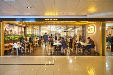 HONG KONG - CIRCA, 2019: İnsanlar New Town Plaza alışveriş merkezindeki Cafe de Coral 'da yemek yiyor. Cafe de Coral Holding, Ltd. fast-food restoran zinciri ve restoran zincirlerinin sahibi ve işletmecisidir.