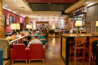 SHENZHEN, ÇİN - CIRCA Kasım 2019 İnsanlar Shenzhen 'deki kitapçıda Up Coffee' de oturuyor.