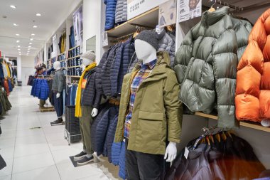 SHENZHEN, ÇİN - CIRCA NOVEMBER, 2019: Shenzhen 'deki Uniqlo mağazasında giysi sergileniyor. Uniqlo bir Japon günlük giyim tasarımcısı, üretici ve perakendecisi..