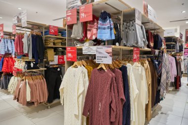 SHENZHEN, ÇİN - CIRCA NOVEMBER, 2019: Shenzhen 'deki Uniqlo mağazasında giysi sergileniyor. Uniqlo bir Japon günlük giyim tasarımcısı, üretici ve perakendecisi..